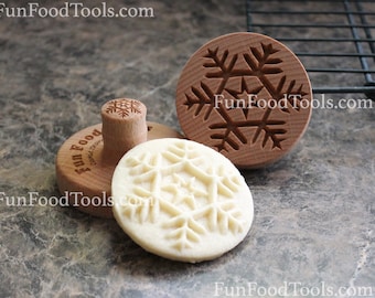 May include: Three wooden snowflake cookie cutters, one with a handle, and a snowflake cookie imprinted with the design of the cutter.