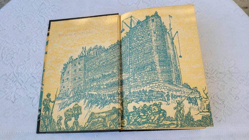 May include: An open book with a yellowed page background and a blue and white illustration of a castle with people surrounding it. The illustration is on both pages of the book.