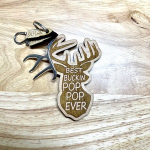 Peut inclure: Porte-cl&eacute;s en bois en forme de t&ecirc;te de cerf avec le texte "Best Buckin' Pop Pop Ever".