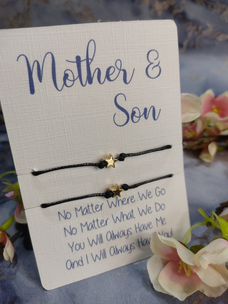 May include: Two black string bracelets with gold star charms. The bracelets are displayed on a white card with the text "Mother & Son" and "No Matter Where We Go No Matter What We Do You Will Always Have Me And I Will Always Have You!"