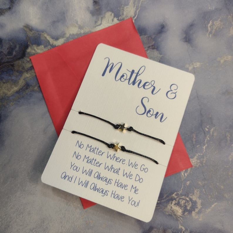 May include: A white card with the text "Mother & Son" and the message "No Matter Where We Go No Matter What We Do You Will Always Have Me And I Will Always Have You!" Two black string bracelets with gold star charms are attached to the card.