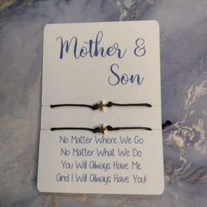 May include: Two black string bracelets with gold star charms. The bracelets are displayed on a white card with the text "Mother & Son" and the message "No Matter Where We Go No Matter What We Do You Will Always Have Me And I Will Always Have You!"