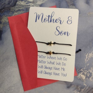 May include: A white card with the text "Mother & Son" and the message "Matter Where We Go Matter What We Do Will Always Have Me Will Always Have You!"  The card is sitting on a red envelope.