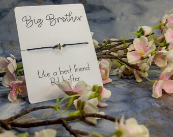 May include: A white card with the text "Big Brother" and "Like a best friend But better." A blue string bracelet with a silver star charm is displayed on the card.