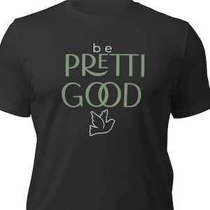 May include: Black t-shirt with the text "be PRETTI GOOD" in a light green font. A light green outline of a dove is below the text. The t-shirt is made of a soft material.