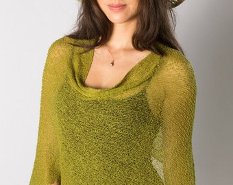 Op de afbeelding: Een chartreuse groene gebreide poncho met een colkraag en een losse, semi-transparante textuur. Het kledingstuk heeft een asymmetrische zoom en korte mouwen, wat een lichte laag over een zwart topje vormt, gecombineerd met een beige en zwarte zonnehoed.