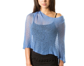 May include: A light blue, loose-knit, semi-sheer poncho with an asymmetrical hemline worn over a black camisole, paired with black shorts featuring a decorative scalloped crochet lace trim along the bottom edge of the garment.