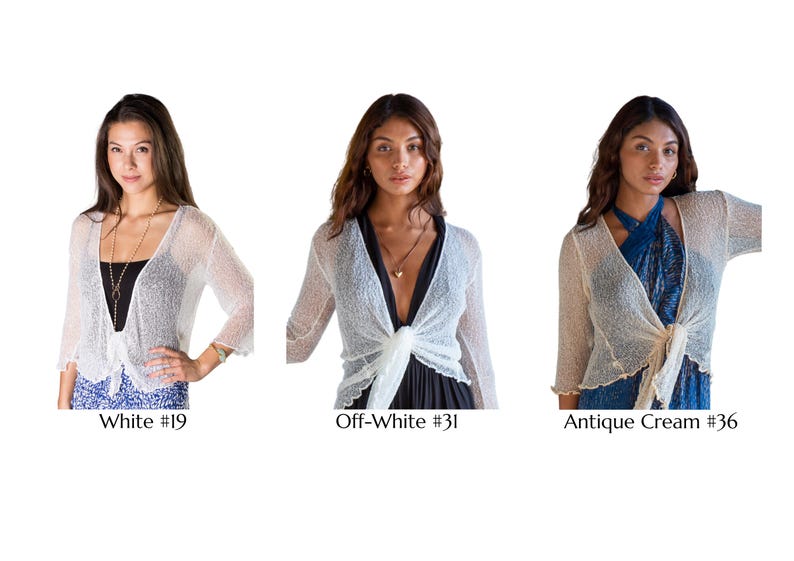 May include: Three cropped shrugs with three-quarter sleeves and a tie-front closure. The shrugs are shown in white labeled #19, off-white labeled #31, and antique cream labeled #36. Each garment features a lightweight, semi-sheer knit texture.