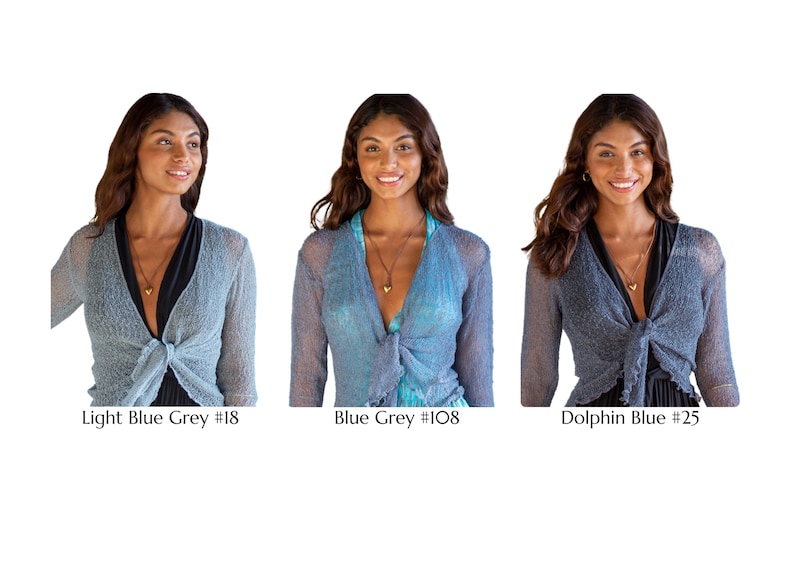 May include: Three long-sleeved, open-front shrugs with a tie-front closure. The colors are labeled as Light Blue Grey #18, Blue Grey #108, and Dolphin Blue #25. Each shrug features a sheer, textured knit fabric with a delicate, lightweight appearance.