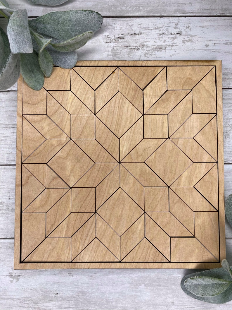 May include: A wooden geometric design puzzle with a light brown finish. The puzzle is made up of many small pieces that fit together to create a larger design.
