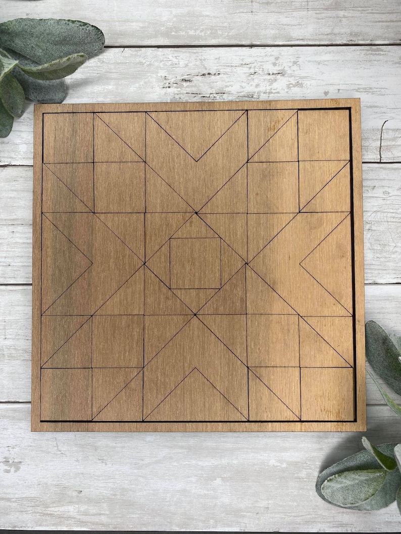 May include: A wooden geometric puzzle with a square frame and a geometric pattern of triangles and squares. The puzzle is made of light brown wood and has a natural wood finish.