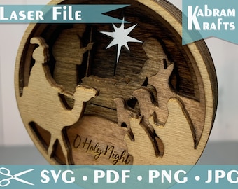 May include: A wooden Christmas ornament featuring a layered design of the nativity scene with the text "O Holy Night". The ornament is circular and has a brown wood finish.