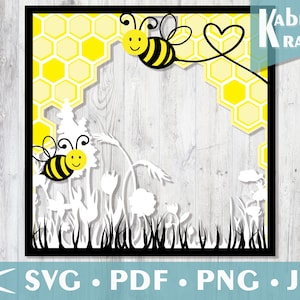 Può includere: Una cornice nera con un motivo a nido d'ape giallo e due api bianche con strisce nere. Le api hanno facce gialle con occhi neri e sorrisi. La cornice è circondata da fiori bianchi ed erba.