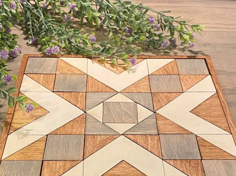 May include: A wooden geometric puzzle with a starburst design. The puzzle is made up of squares and triangles in shades of brown, grey, and white.