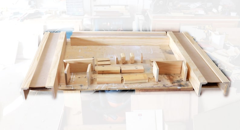 May include: A set of unfinished wooden pieces for building a frame. The pieces are arranged on a workbench, ready to be assembled.