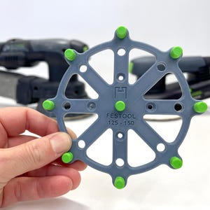 May include: A gray sanding disc holder with green knobs. The holder is labeled "FESTOOL 125 - 150".