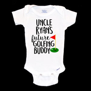 May include: White baby grow with black text that reads "Uncle Ryan's future golfing buddy" with a red golf flag and green golf hole graphic.