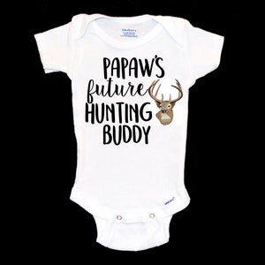 May include: White baby onesie with black text that reads "Papaw's future hunting buddy" and a brown deer head graphic.