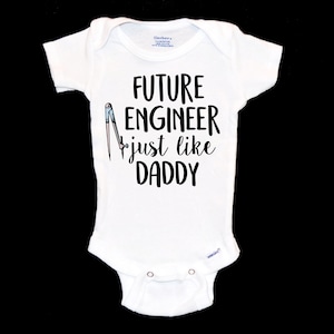 May include: White baby onesie with black text that reads "FUTURE ENGINEER just like DADDY" and a drawing of a compass.