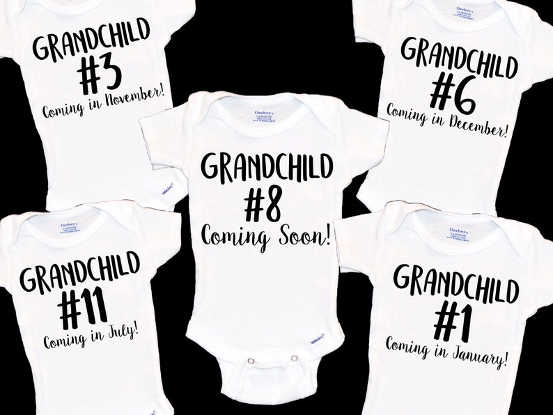 May include: Five white baby onesies with black text. The onesies announce the arrival of a grandchild with a number and month. The text reads: "Grandchild #3 Coming in November!" "Grandchild #11 Coming in July!" "Grandchild #8 Coming Soon!" "Grandchild #6 Coming in December!" "Grandchild #1 Coming in January!"