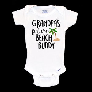 May include: White baby onesie with black text that reads "Grandpa's future beach buddy" with a green palm tree graphic.