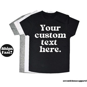 May include: Three t-shirts in black, white and grey with the text "Your custom text here." printed in white on the black t-shirt.