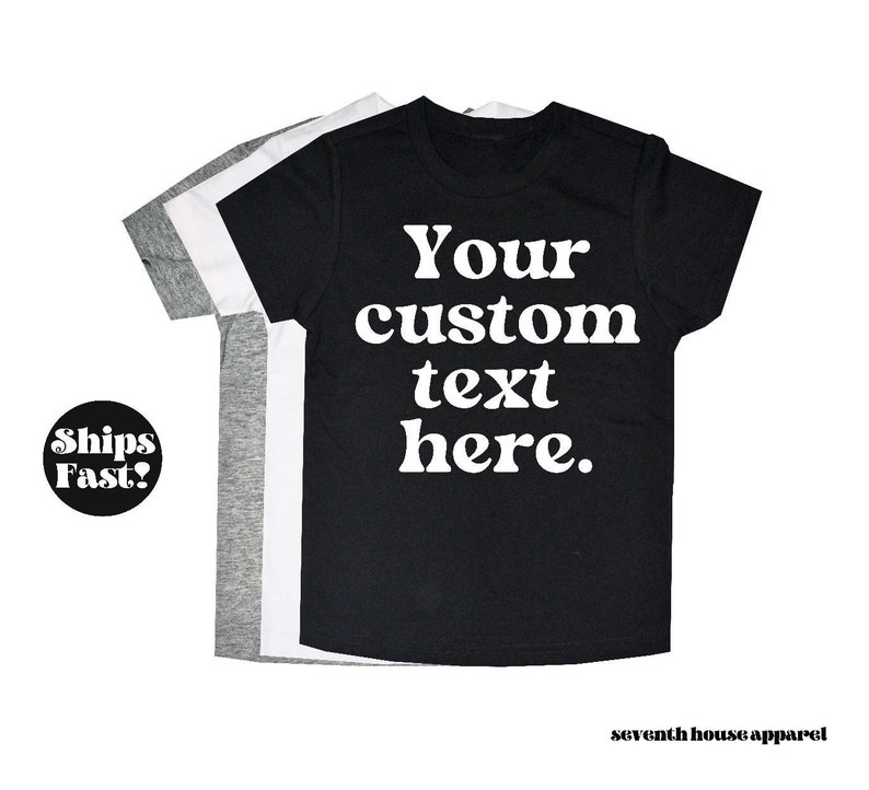 May include: Three t-shirts in black, white and grey with the text "Your custom text here." printed in white on the black t-shirt.