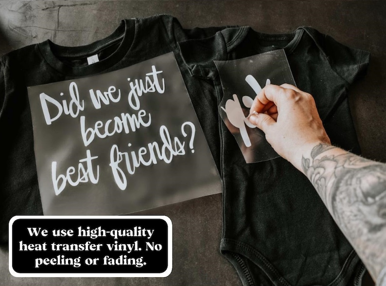 May include: Two black t-shirts with white vinyl heat transfer designs. The larger shirt says "Did we just become best friends?" and the smaller shirt has a simple design. The text "We use high-quality heat transfer vinyl. No peeling or fading." is visible below the shirts.