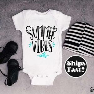 May include: White baby onesie with black text that says "Summer Vibes -only-" in a playful font. The text is accented with a turquoise blue design.