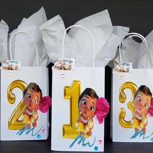 May include: Three white gift bags with handles, each decorated with a gold number, a cartoon character, and pink flowers. The numbers are 2, 1, and 3. The bags have the text "Thank you for coming" on them.
