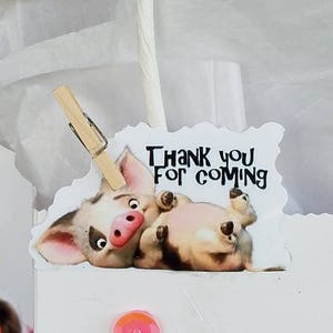 May include: A white gift bag with a pink sequin and a sticker of a cartoon pig with the text "Thank you for coming".