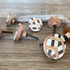May include: Set of eight wooden cabinet knobs with a geometric pattern in shades of brown, white and black.