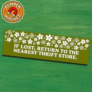 May include: A green bumper sticker with white floral patterns and the text "IF LOST, RETURN TO THE NEAREST THRIFT STORE." A round magnet with a horseshoe magnet graphic is in the upper left corner.