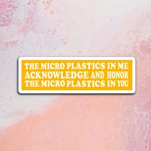 Peut inclure: Un autocollant rectangulaire avec un fond jaune et une bordure blanche. Le texte sur l'autocollant se lit comme suit : "THE MICRO PLASTICS IN ME ACKNOWLEDGE AND HONOR THE MICRO PLASTICS IN YOU." L'autocollant est placé sur un fond marbré rose et blanc.