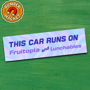 May include: A bumper magnet with the text "THIS CAR RUNS ON Fruitopia and Lunchables" in blue and purple. The magnet has a holographic background. A round magnet with the words "BUMPER MAGNET" and a horseshoe magnet graphic is in the upper left corner.