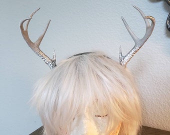 May include: Silver deer antler headband with a white wig on a mannequin head.