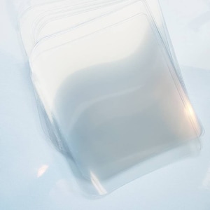 May include: A stack of clear plastic sleeves, likely for protecting documents or photographs.