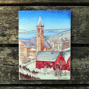 May include: A watercolor painting of a red brick building with a clock tower. The building is covered in snow and surrounded by trees. The sky is blue with white stars. The painting is signed "Cheryl Chalmers".