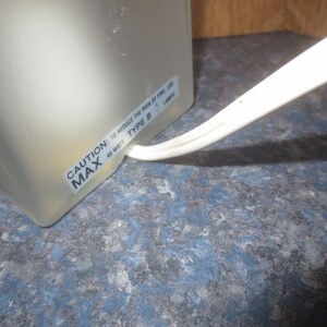 May include: Close-up of a white lamp base with a warning label that reads "CAUTION: TO REDUCE THE RISK OF FIRE, USE 40 WATT MAX TYPE B LAMP".