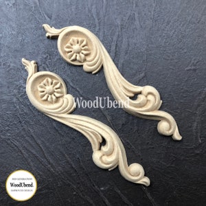 May include: Two unfinished wooden decorative scroll ornaments with a floral design. The ornaments are made by WoodUbend.