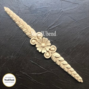 May include: A wooden decorative trim with a floral design. The trim is light brown and has a carved flower with leaves on either side. The trim is 30.5 cm long.