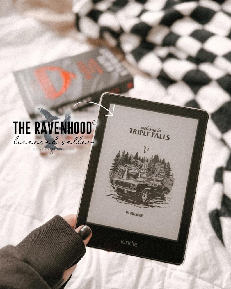May include: A Kindle e-reader displaying the cover of the book "Welcome to Triple Falls" by The Ravenhood. The cover features a black muscle car driving through a forest.