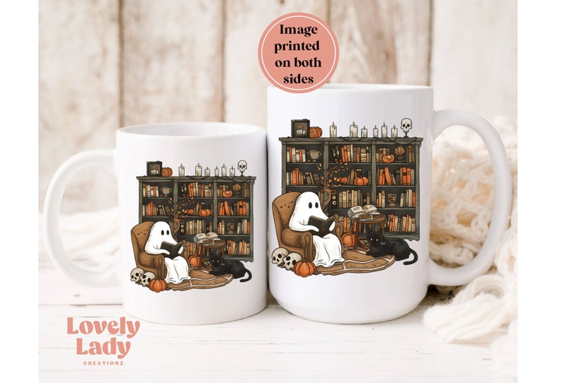 May include: Two white ceramic mugs with a design of a ghost reading a book in a library setting with bookshelves, pumpkins, and a black cat. The image is printed on both sides of the mug.