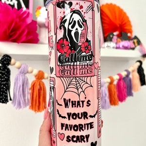 May include: Pink and white stainless steel tumbler with a graphic of a ghost wearing a mask and holding a phone. The text on the tumbler says "Call me Call me Call me" and "What's your favorite scary movie".