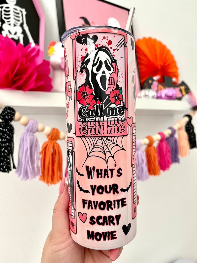 May include: Pink and white stainless steel tumbler with a graphic of a ghost wearing a mask and holding a phone. The text on the tumbler says "Call me Call me Call me" and "What's your favorite scary movie".