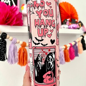 May include: Pink and black tumbler with a graphic of a ghost holding a phone and the text "No You Hang Up".