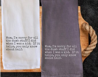 May include: Two kitchen towels, one white and one gray, are displayed on a wooden cutting board. Each towel has the text "Mom, I'm sorry for all the dumb stuff I did when I was a kid. If it helps, you only know about half."