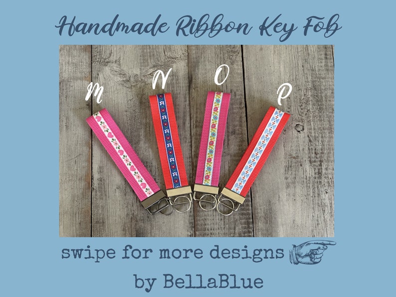 May include: Handmade ribbon key fobs in pink and red with floral and geometric patterns. Each fob has a metal clasp and key ring. The image includes the text "Handmade Ribbon Key Fob", "swipe for more designs", and "by BellaBlue".