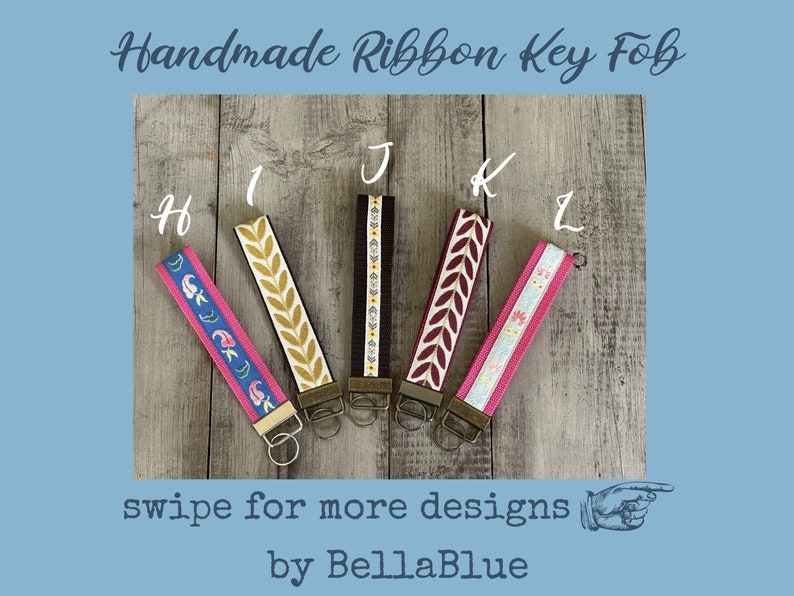 May include: Handmade ribbon key fobs in various designs. The key fobs feature colorful patterns, including floral and leaf motifs. Each fob has a metal clasp and key ring. The text "swipe for more designs" is visible.