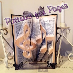 May include: A book with pages folded into the shape of musical notes. The book is standing upright on a black stand with two black butterflies on either side. The title "Patterns for Pages" is written in pink letters across the top of the image.